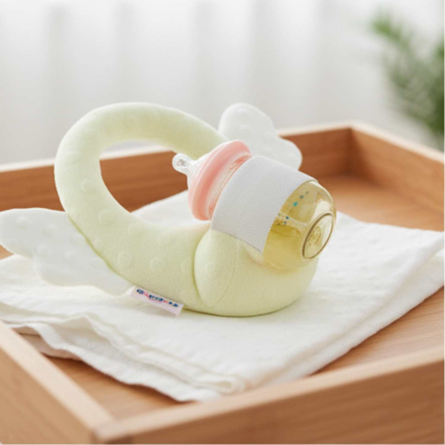 Baby bottle with a pacifier on a white cloth on a wooden surface