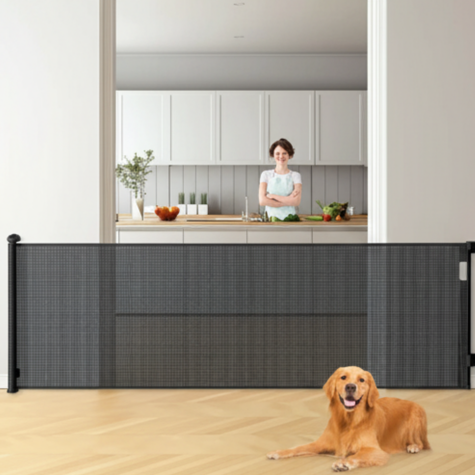 Dog siting behind a black pet gate in a kitchen with a woman in the background
