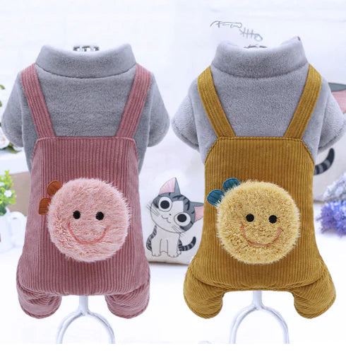 Two corduroy overalls with cartoon face designs on a white background